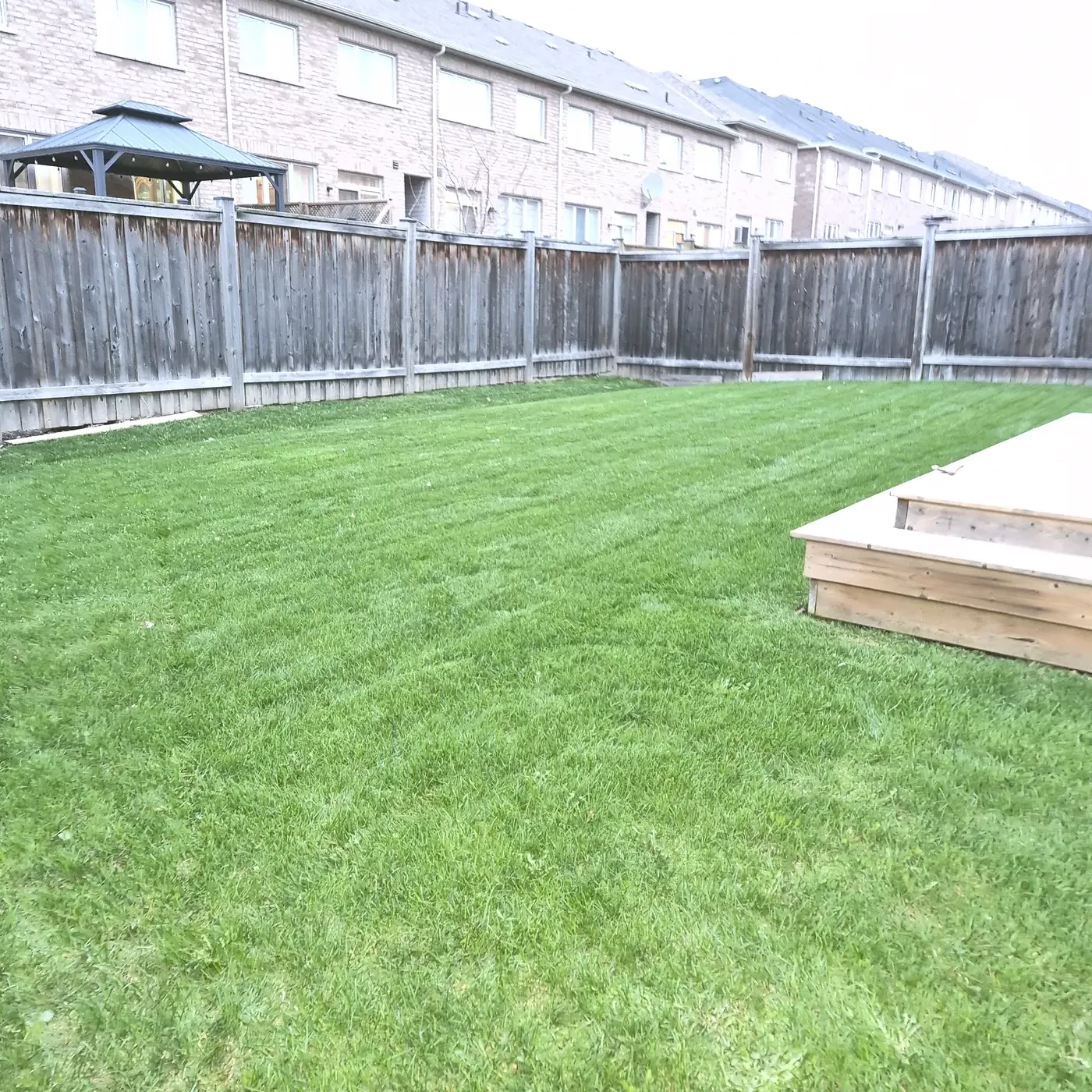 A freshly cut, striped residential lawn by Garuda Lawn Care