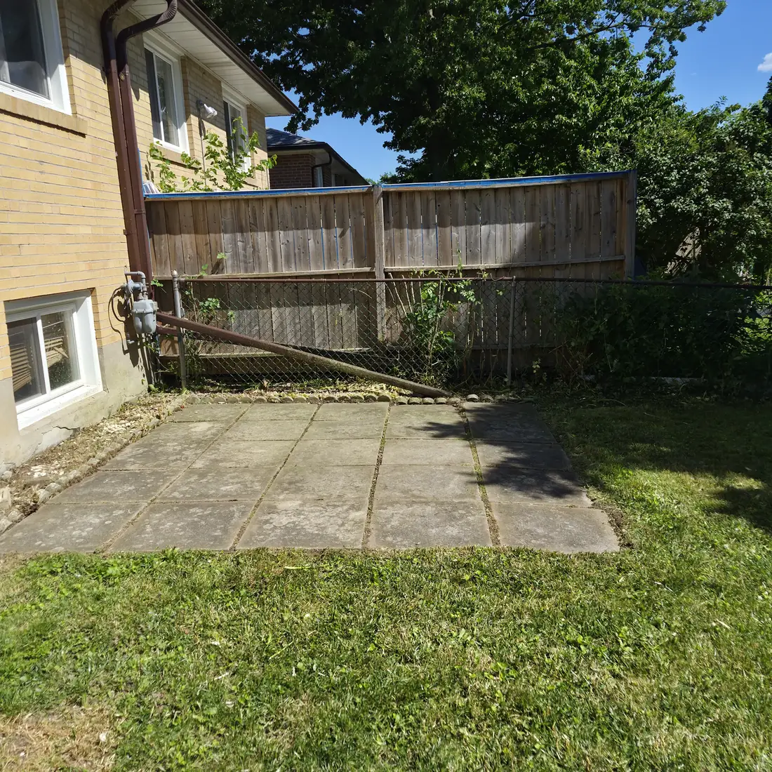 The same yard after cleanup, the stone pad and seating clear again.